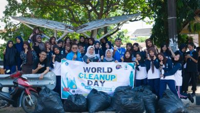 Siswa dan guru SMKN 3 Jepara berfoto bersama membawa spanduk World Cleanup Day 2026 dengan tumpukan kantong sampah hitam di depan mereka sebagai hasil aksi kebersihan lingkungan.