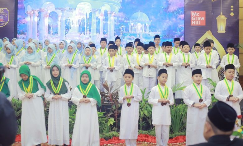 Ratusan murid SD Muhammadiyah PK Solo berbaris di panggung mengenakan seragam wisuda putih, jilbab, peci, dan kalung medali hijau-kuning saat prosesi Wisuda Tahfiz dan Tilawah.