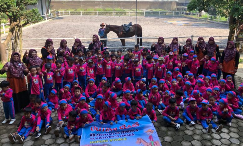 Foto bersama ratusan siswa TK Aisyiyah di Hufadz Stable dengan latar belakang kuda dan pelatih.