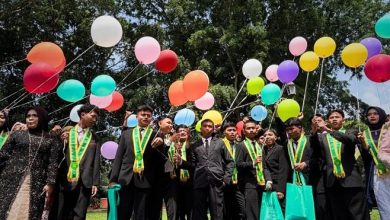 Wisudawan SMK Muhammadiyah 1 Temanggung berfoto dengan balon di area terbuka.
