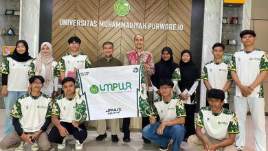 Wakil Rektor III UMPWR Dr. Budi Setiawan bersama tujuh mahasiswa atlet memegang bendera logo UMPWR dalam acara pelepasan delegasi The 1st Muhammadiyah Games 2026.