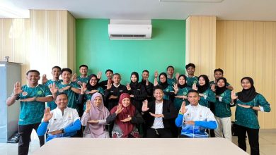 Foto bersama jajaran guru dan siswa tim kreatif SMK Mutu Wonosobo di dalam ruangan dengan pose tangan simbol profesionalisme.