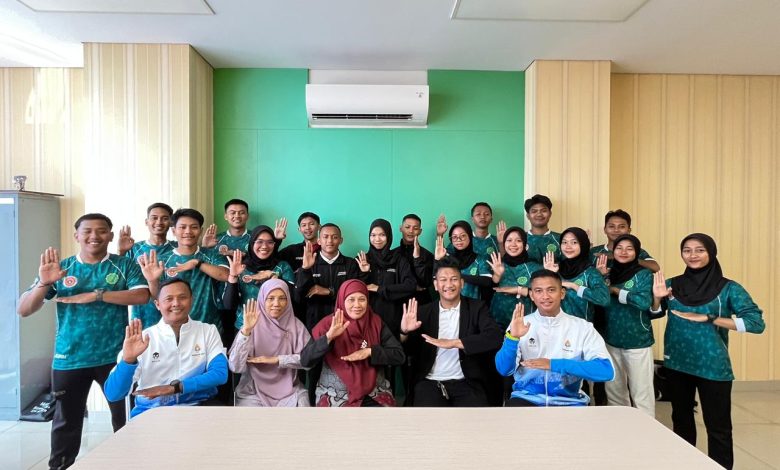 Foto bersama jajaran guru dan siswa tim kreatif SMK Mutu Wonosobo di dalam ruangan dengan pose tangan simbol profesionalisme.