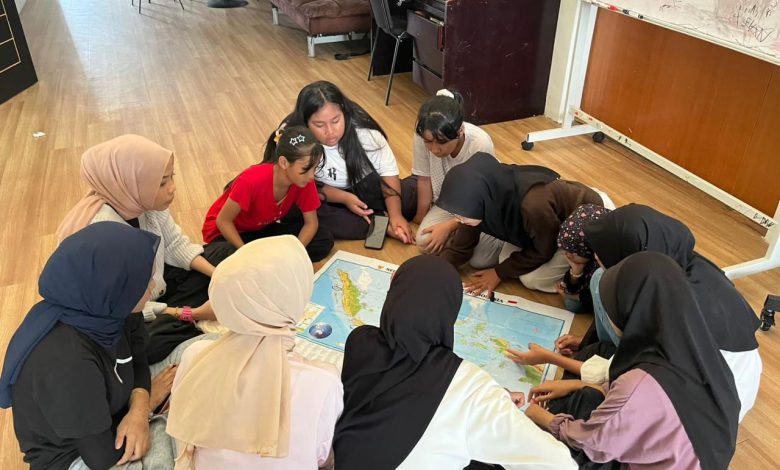 Mahasiswa KKN Internasional UMS sedang mendampingi anak-anak Sanggar Bimbingan Elshaddai Malaysia belajar peta wilayah Indonesia.