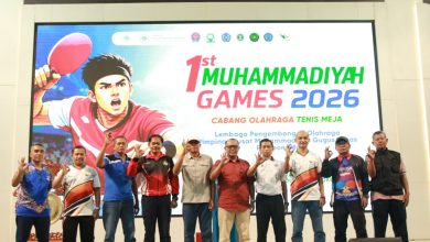 Panitia dan pengurus LPO PP Muhammadiyah berfoto bersama dengan pose tiga jari di panggung pembukaan 1st Muhammadiyah Games 2026 di Universitas Muhammadiyah Purwokerto.