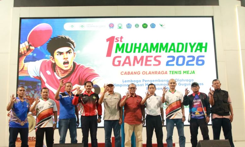 Panitia dan pengurus LPO PP Muhammadiyah berfoto bersama dengan pose tiga jari di panggung pembukaan 1st Muhammadiyah Games 2026 di Universitas Muhammadiyah Purwokerto.