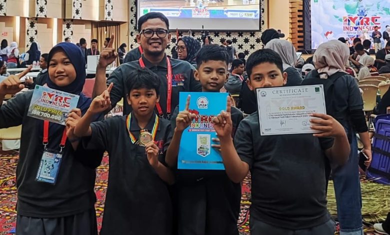 Tim Smart Robo SD UMP memegang sertifikat Gold Award dan medali kemenangan dalam ajang kompetisi robotik ASEAN IYRC 2026 di Jakarta.