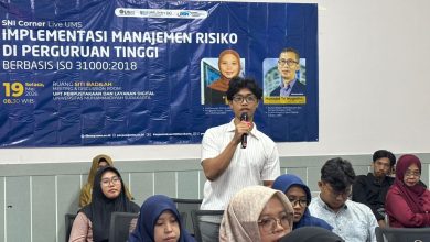 Seorang peserta pria berdiri memegang mikrofon saat bertanya dalam acara SNI Corner Live UMS mengenai manajemen risiko perguruan tinggi berbasis ISO 31000:2018.