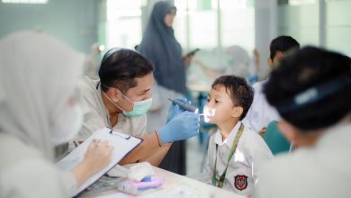 Mahasiswa profesi dokter gigi FKG UMS sedang melakukan pemeriksaan atau screening kesehatan gigi pada seorang siswa SDIT Nur Hidayah Surakarta menggunakan senter medis.