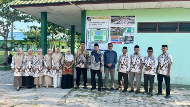 Para guru dan jajaran pimpinan SMA Muhammadiyah 2 Palangkaraya berfoto bersama tim penjaminan mutu PP Muhammadiyah di depan maket sport center sekolah.