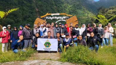Anggota Bikers Mu Doro membentangkan spanduk saat foto bersama di depan gerbang selamat datang wisata Telogo Mangunan Petungkriyono Pekalongan