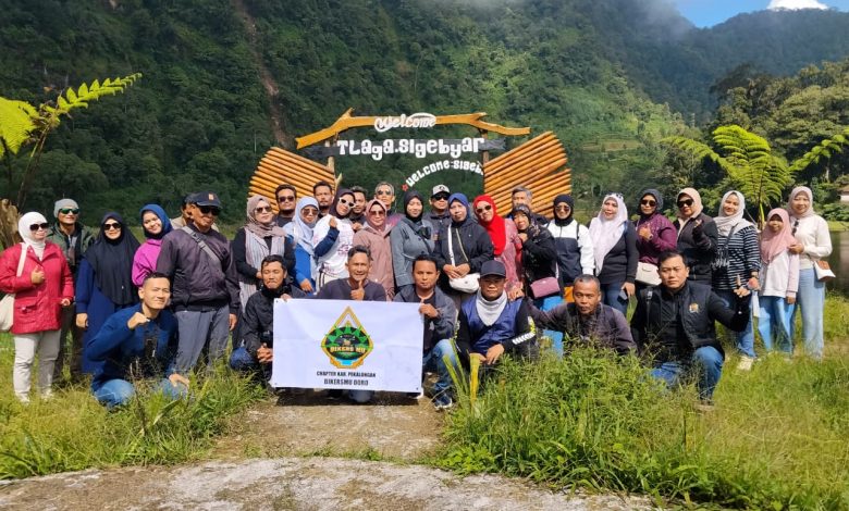 Anggota Bikers Mu Doro membentangkan spanduk saat foto bersama di depan gerbang selamat datang wisata Telogo Mangunan Petungkriyono Pekalongan