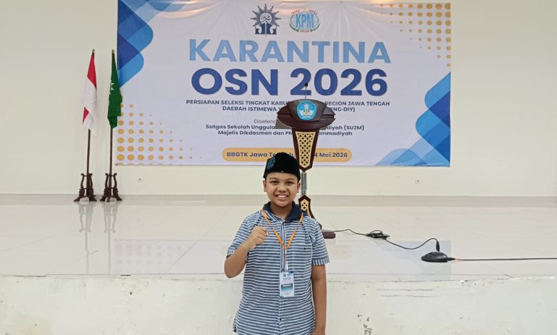 Anagha Damar Ranu siswa SD Muhammadiyah Palur berpose mengepalkan tangan di depan panggung Karantina OSN 2026.