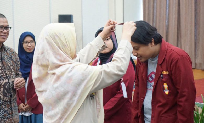 Penyematan tanda peserta oleh Rektor UNIMMA Lilik Andriyani kepada perwakilan kader IMM dalam pengukuhan Relawan Muhammadiyah Holistic IMM Care.