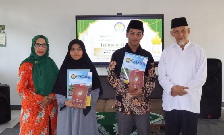 Foto bersama dua santri tahfidz 30 juz, Miftahul Jannah dan Dzarif Mudzaffar, membawa mushaf Al-Qur'an dan piagam penghargaan didampingi pengurus Pondok Pesantren Darul Arqom Muhammadiyah Bayan Purworejo saat acara Istima’ul Qur’an.