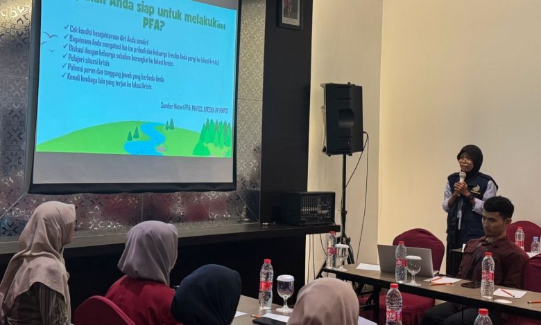 Suasana pelatihan Psychological First Aid (PFA) di Magelang menampilkan pemateri menjelaskan cara mencegah PTSD di depan layar proyektor kepada para relawan.