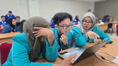 Tiga mahasiswa FKG UMS berjaket almamater toska sedang serius berdiskusi di depan laptop saat kompetisi kedokteran gigi nasional Odontobattle 2.0.