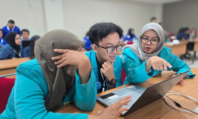 Tiga mahasiswa FKG UMS berjaket almamater toska sedang serius berdiskusi di depan laptop saat kompetisi kedokteran gigi nasional Odontobattle 2.0.