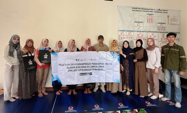 Tim pengabdian masyarakat UMP foto bersama pelaku UMKM Srikandi Cipta Bahari Semarang memegang spanduk pelatihan pemasaran digital olahan ikan.