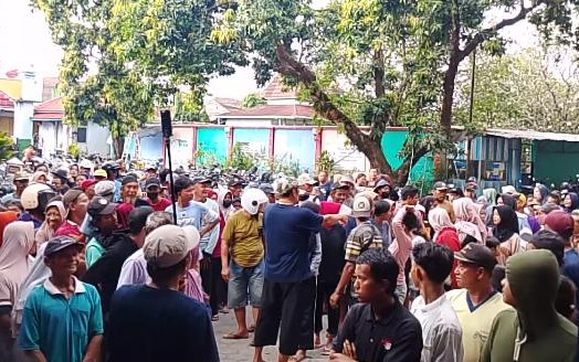 Foto kerumunan warga Kalinyamatan, Jepara, yang antusias mengantri dan berkumpul untuk menerima pembagian daging qurban Idul Adha secara gratis di halaman masjid/mushola, menunjukkan suasana penuh semangat tanpa kupon.