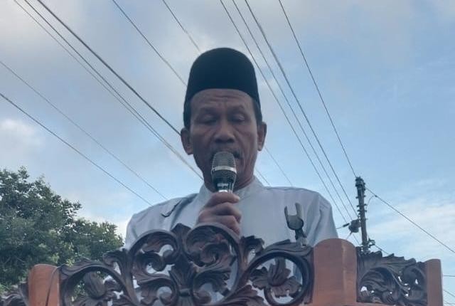 Foto khatib Salat Idul Adha 2026 Jepara, Labib Dzakwan Faiq, saat menyampaikan khutbah di atas mimbar kayu di halaman Masjid An-Nur Gelang, Keling.