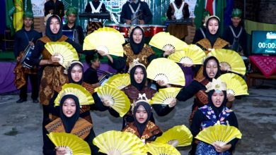 Kelompok peserta remaja masjid mengenakan busana batik bertema alam dan memegang kipas kuning saat tampil dalam kompetisi lomba takbir Idul Adha kreatif AMM Gading.