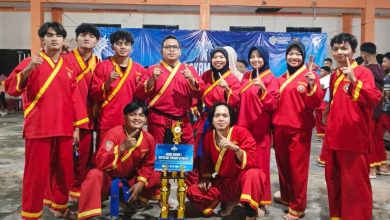 Foto bersama tim Tapak Suci Universitas Muhammadiyah Gombong (UNIMUGO) dalam seragam merah memegang piala Juara Umum 1.