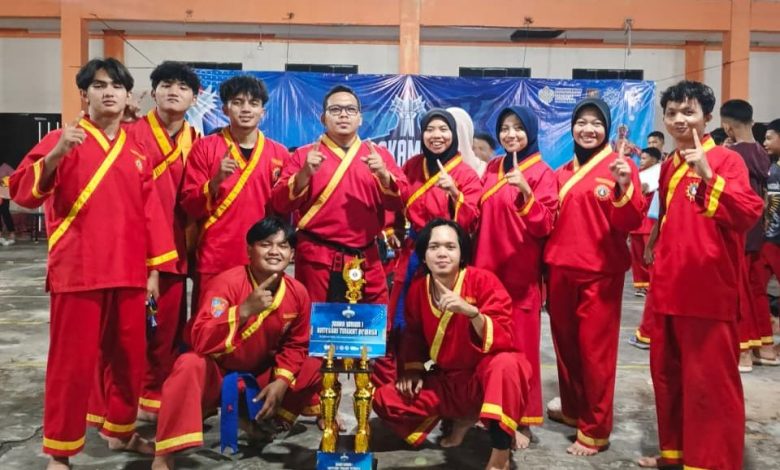 Foto bersama tim Tapak Suci Universitas Muhammadiyah Gombong (UNIMUGO) dalam seragam merah memegang piala Juara Umum 1.