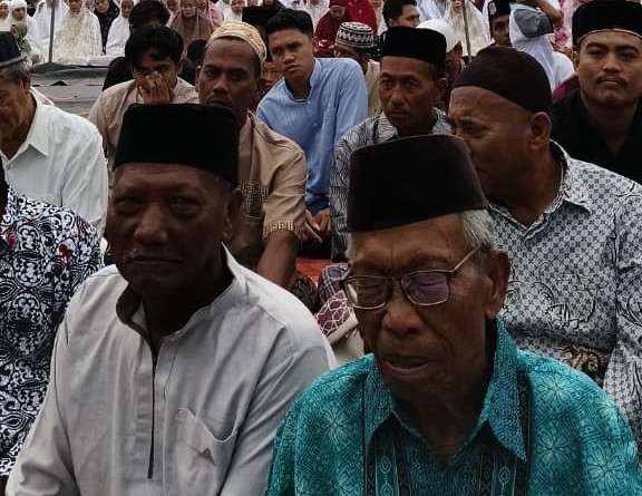 Ribuan jemaah pria mengenakan peci dan baju koko mendengarkan khutbah Idul Adha dengan khusyuk di Desa Sidokumpul