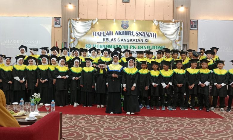 Siswa-siswi kelas 6 SD Muhammadiyah PK Banyudono mengenakan toga wisuda saat berfoto bersama dalam acara Haflah Akhirussanah Angkatan XII di atas panggung.