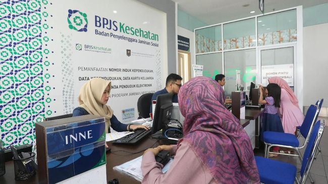 Petugas administrasi melayani warga di loket kantor BPJS Kesehatan untuk pengurusan program Jaminan Kesehatan Nasional (JKN).