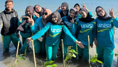 Mahasiswa Universitas 'Aisyiyah Yogyakarta berpose bersama di area penanaman 1.500 bibit mangrove di Pantai Baros, Bantul sebagai wujud Fikih Hijau.