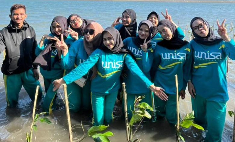 Mahasiswa Universitas 'Aisyiyah Yogyakarta berpose bersama di area penanaman 1.500 bibit mangrove di Pantai Baros, Bantul sebagai wujud Fikih Hijau.