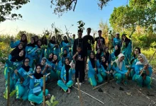 Mahasiswa UNISA Yogyakarta berpose bersama bibit mangrove sebelum melakukan penanaman untuk menjaga ekosistem pesisir mangrove di Pantai Baros