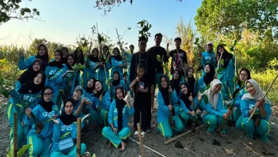 Mahasiswa UNISA Yogyakarta berpose bersama bibit mangrove sebelum melakukan penanaman untuk menjaga ekosistem pesisir mangrove di Pantai Baros