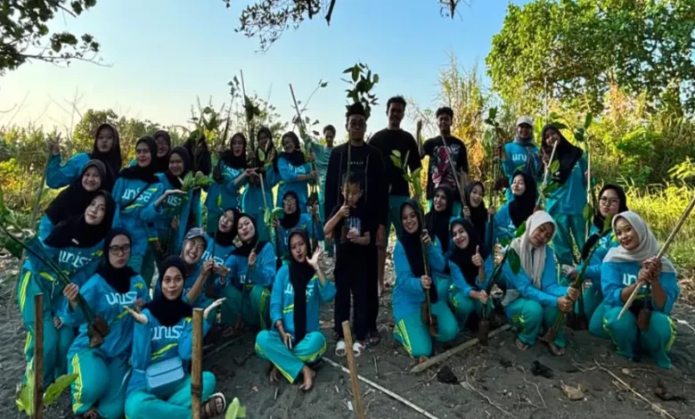 Mahasiswa UNISA Yogyakarta berpose bersama bibit mangrove sebelum melakukan penanaman untuk menjaga ekosistem pesisir mangrove di Pantai Baros