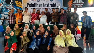 Sekelompok peserta Pelatihan Instruktur MPKSDI PDM Pati berfoto bersama di Smart Class SD Muhati, berpose menunjuk kamera dengan latar belakang spanduk acara dan mural bertema luar angkasa.