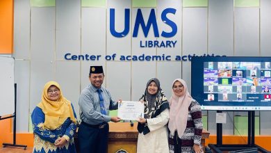 Empat orang pengurus/dosen berfoto bersama saat penyerahan sertifikat di UMS Library dengan latar belakang layar zoom meeting hybrid.