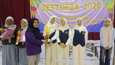 Lima siswi berhijab dari SMA Muhammadiyah 2 Mayong menerima piala di panggung acara ZESTOPIA 2026. Seorang wanita menyerahkan piala kepada seorang siswi di depan spanduk acara.