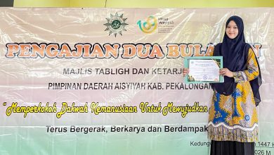 Nagita Histimuna Aisyah memegang piagam penghargaan Juara 1 lomba video kultum di depan spanduk Majelis Tabligh dan Ketarjihan Aisyiyah Kabupaten Pekalongan.
