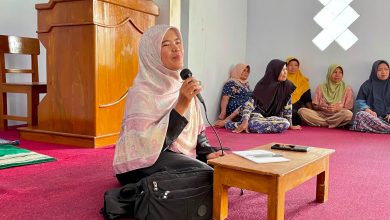 Seorang wanita berjilbab sedang berbicara menggunakan mikrofon saat memberikan penyuluhan kesehatan kepada warga dalam kegiatan Safari Qurban di Desa Mesoyi.