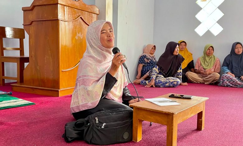 Seorang wanita berjilbab sedang berbicara menggunakan mikrofon saat memberikan penyuluhan kesehatan kepada warga dalam kegiatan Safari Qurban di Desa Mesoyi.