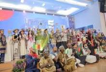Foto bersama rektor UMS Prof. Dr. Harun Joko Prayitno, M.Hum. dan pimpinan universitas dengan peserta internasional ICAC 2026 yang mengibarkan bendera berbagai negara di panggung audtorium.