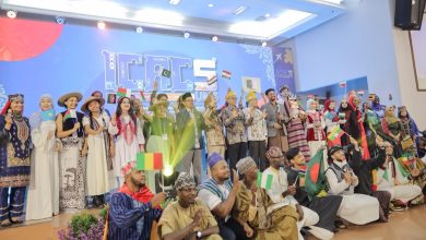 Foto bersama rektor UMS Prof. Dr. Harun Joko Prayitno, M.Hum. dan pimpinan universitas dengan peserta internasional ICAC 2026 yang mengibarkan bendera berbagai negara di panggung audtorium.