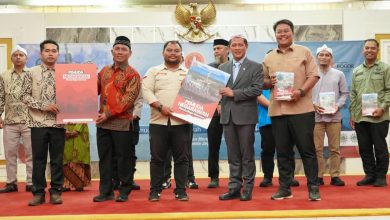 Wamenko Pangan Hanif Faisol Nurofik dan Pengurus Pemuda Muhammadiyah Bogor Memegang Buku di Panggung