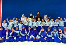 Foto bersama siswa SD BUMIMU Adiwerna Tegal yang ceria bersama empat mahasiswa internasional UMP asal Sudan, Palestina, Mali, dan Maroko dalam program pertukaran budaya global 'Meet and Greet with English Speakers'.