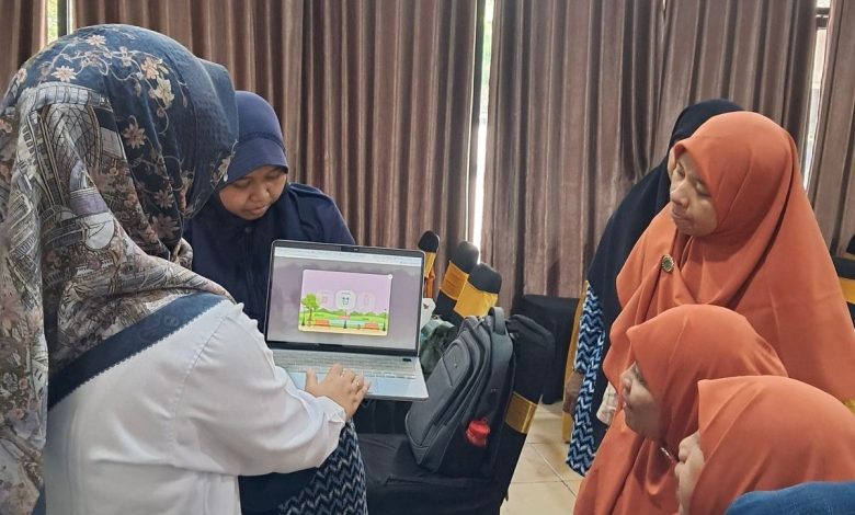 Tim PkM UMS menunjukkan cara penggunaan digital storybook untuk mencegah perundungan anak usia dini kepada guru PAUD