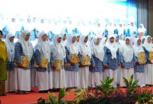 Foto yang menampilkan barisan guru TK ABA di Kebumen, berkerudung putih dan mengenakan seragam biru corak batik, berdiri bangga di atas panggung di UNIMUGO sembari memegang sertifikat penghargaan pada Milad ke-109 ‘Aisyiyah.