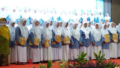 Foto yang menampilkan barisan guru TK ABA di Kebumen, berkerudung putih dan mengenakan seragam biru corak batik, berdiri bangga di atas panggung di UNIMUGO sembari memegang sertifikat penghargaan pada Milad ke-109 ‘Aisyiyah.