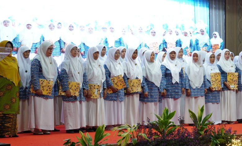 Foto yang menampilkan barisan guru TK ABA di Kebumen, berkerudung putih dan mengenakan seragam biru corak batik, berdiri bangga di atas panggung di UNIMUGO sembari memegang sertifikat penghargaan pada Milad ke-109 ‘Aisyiyah.